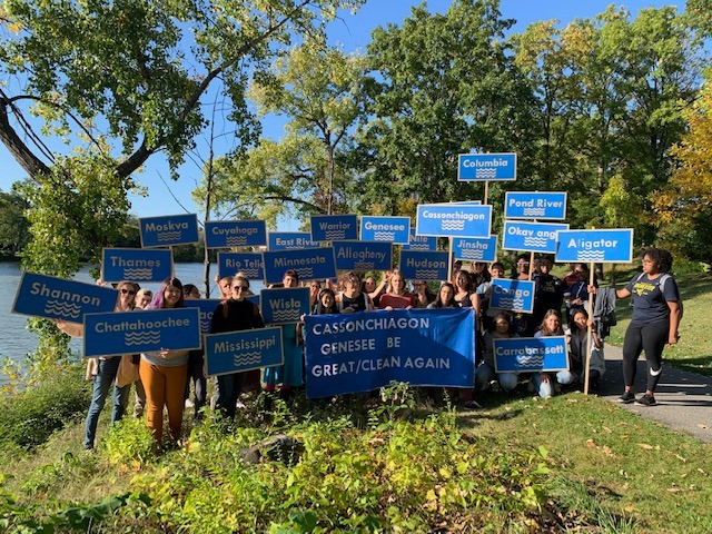 Students with signs by river