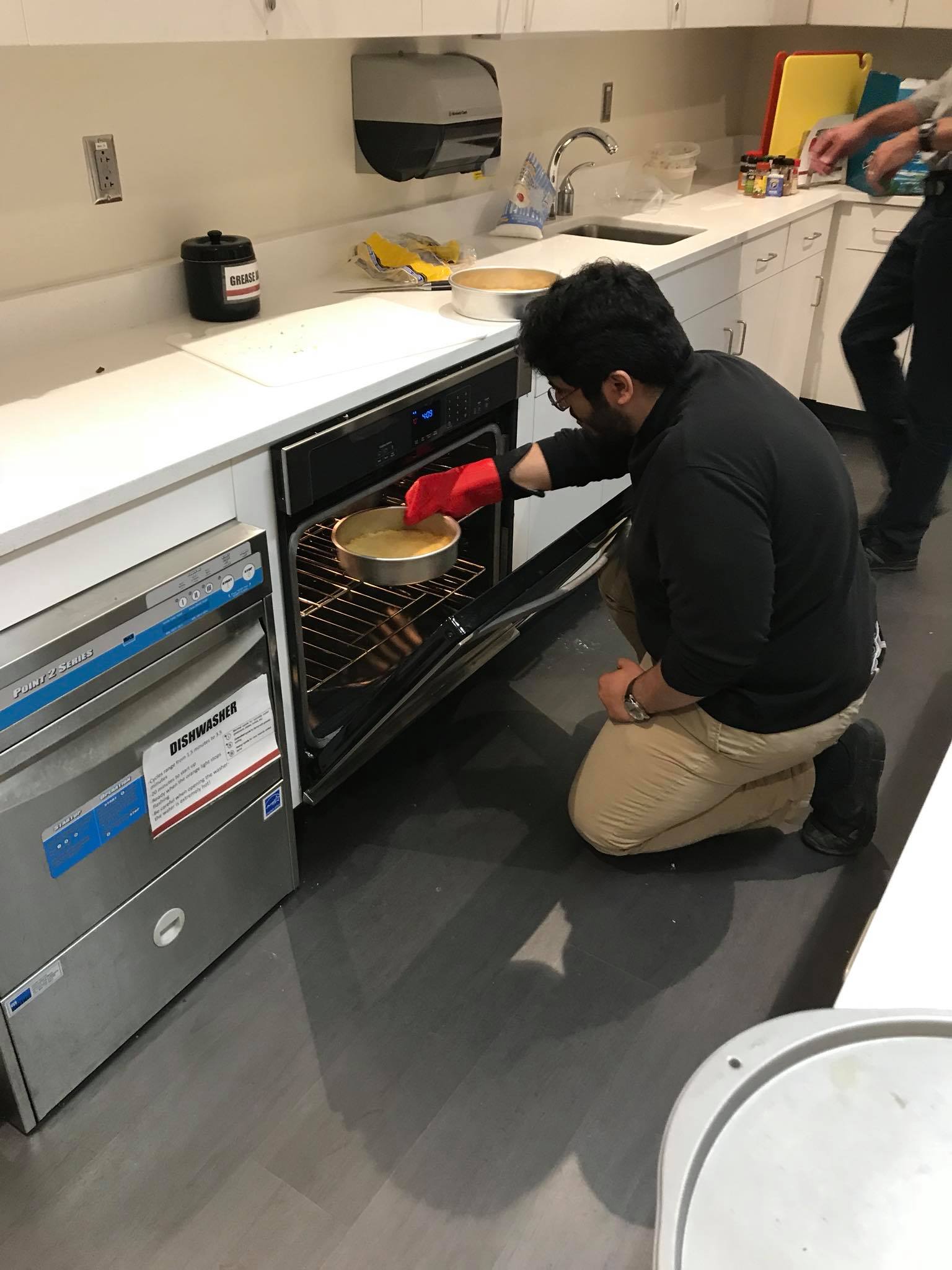 Student pulling baked item out of an oven