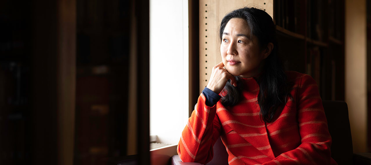 Portrait of June Hwang sitting in a chair, smiling