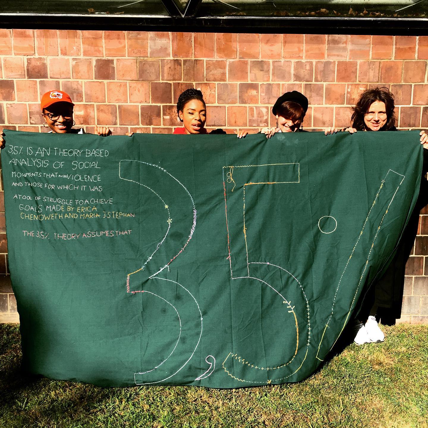 Students display embroidered banner