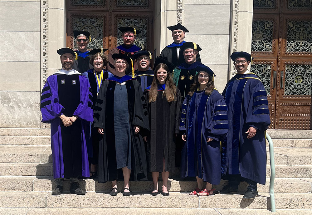 A group photo of the members of the department on the steps of Rush Rhees Library.