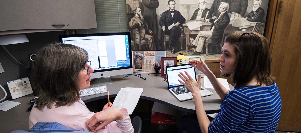 A graduate student talking with a librarian.