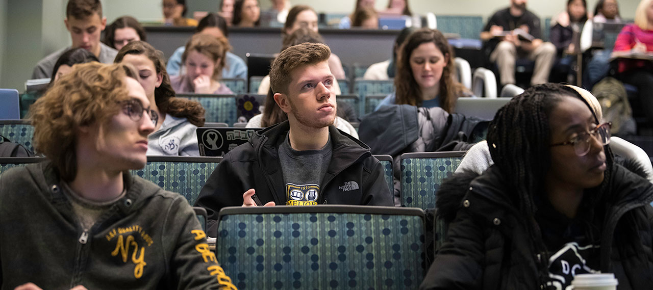 Students in class listening to a professor.