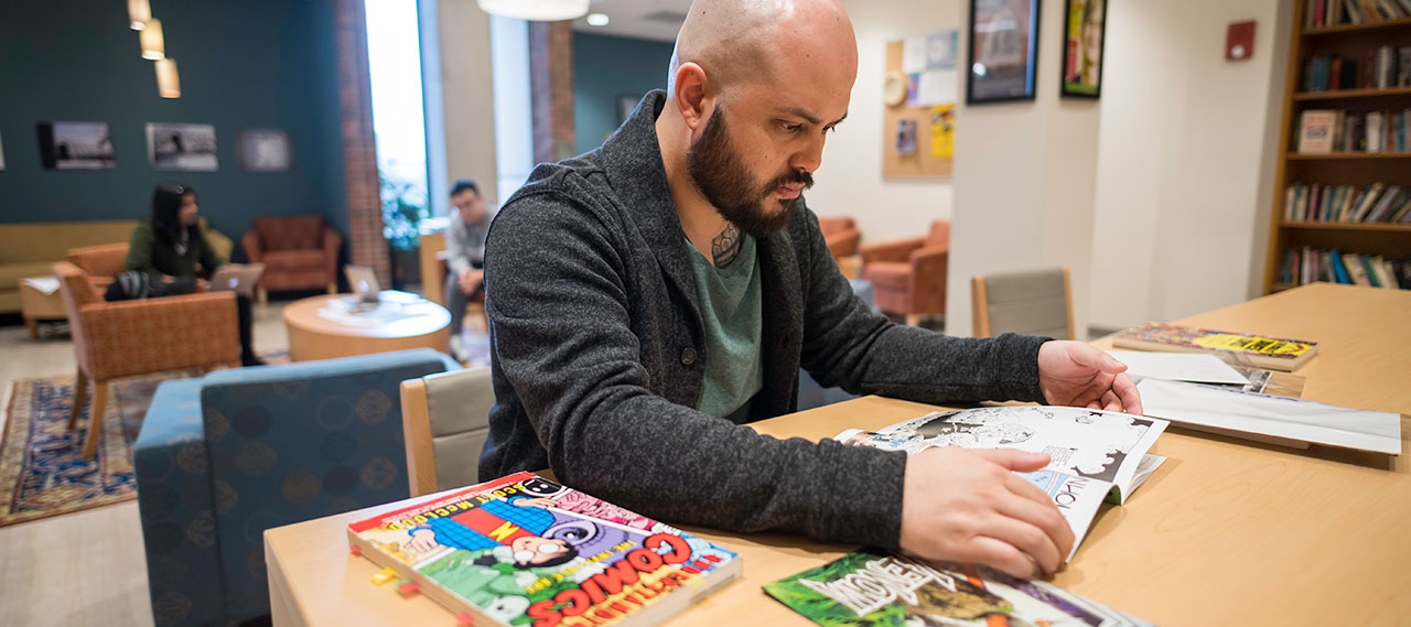 A student browsing through books in the Humanities Center.