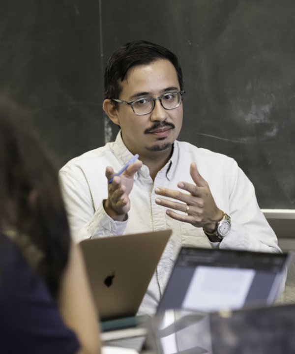 Pablo sitting at a desk with students.