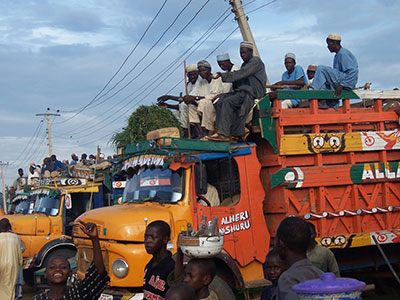 People riding on top of a truck.