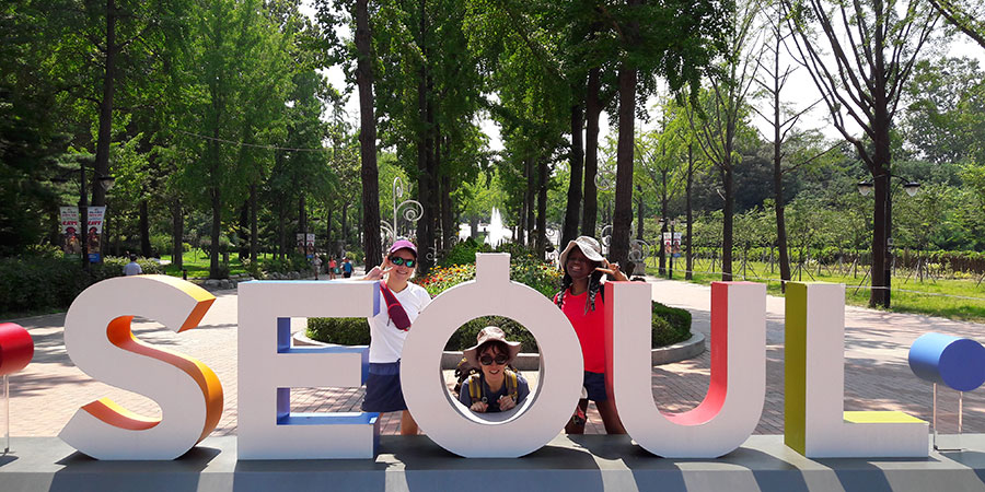 Students posing behind a Seoul sign.