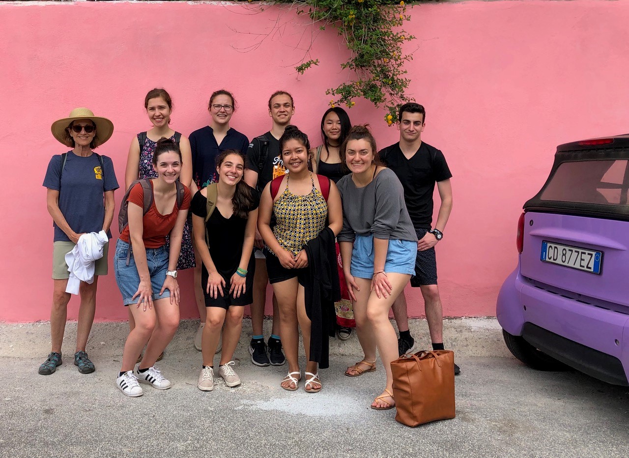 A group photo in front of a pink wall.