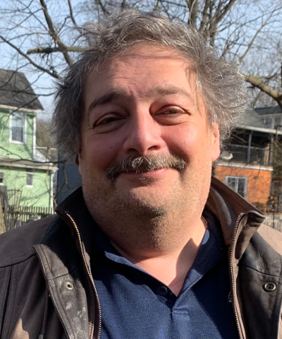 Headshot of Dmitry Bykov standing outside and smiling at the camera.