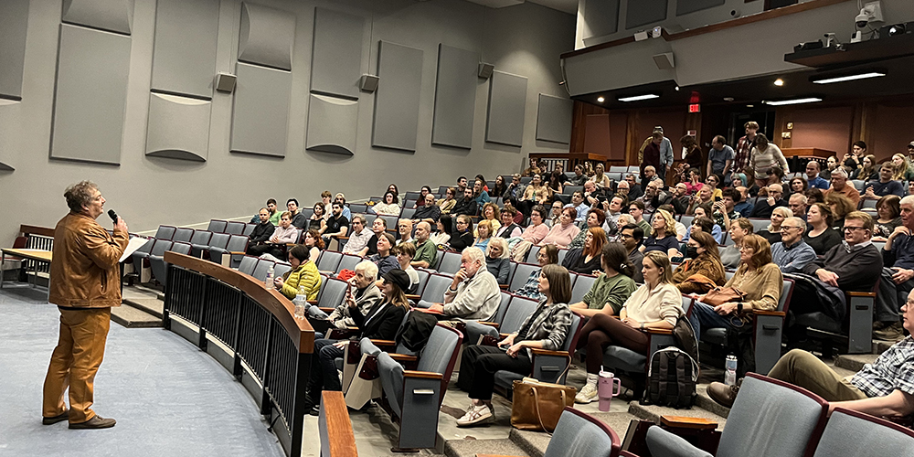 Dmitry Bykov speaks before an audience in an auditorium.