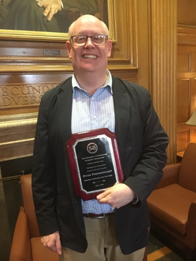 Dr Prendergast holds his award plaque