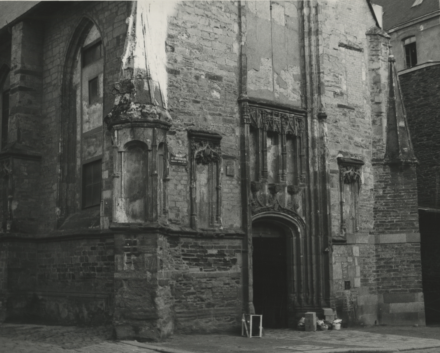 black and white photo of the front and entrance of an old brick building