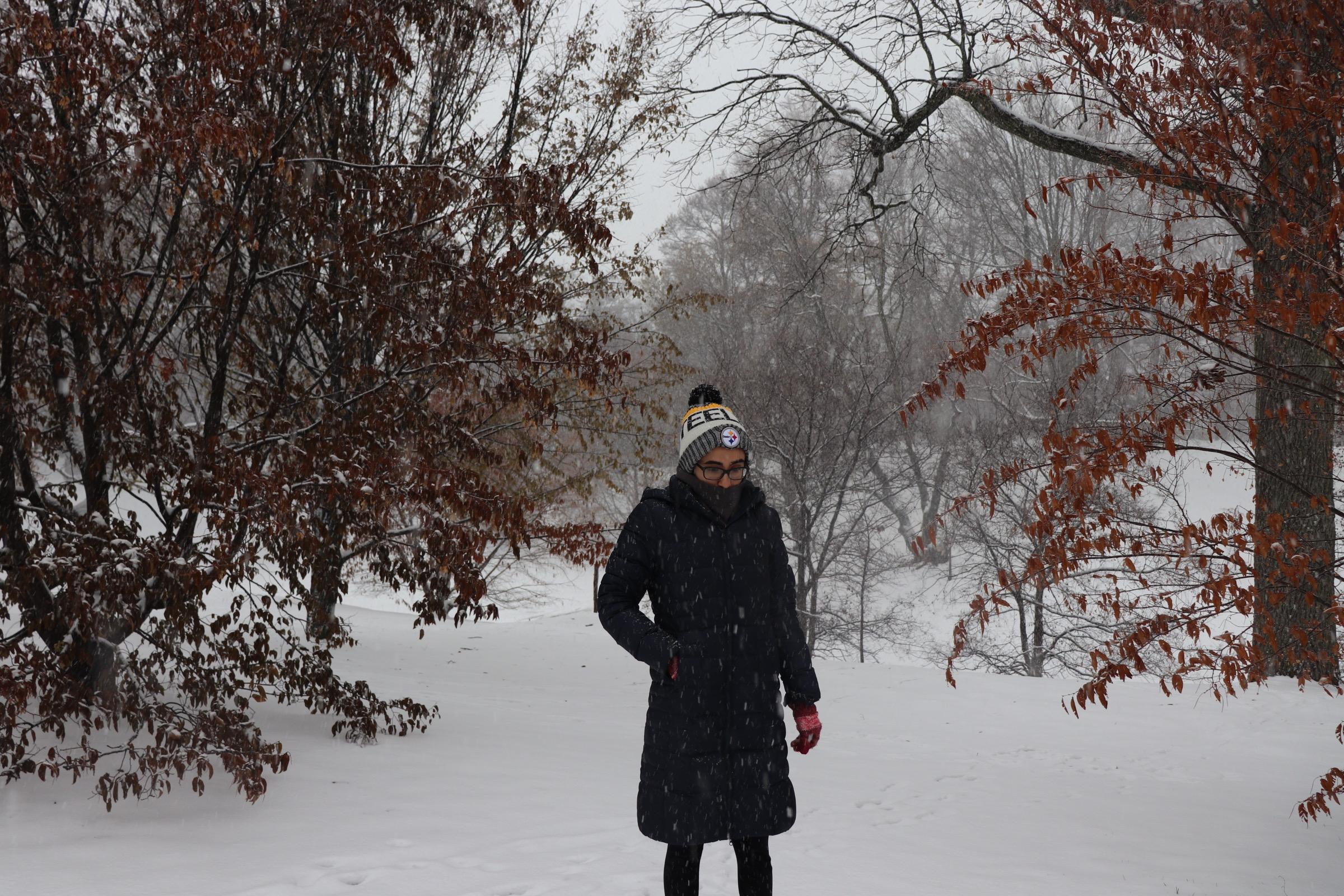 girl standing in a snowy forest clearing