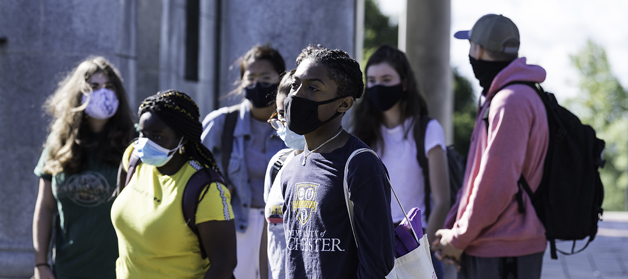 A group of students wearing masks while on a field trip.