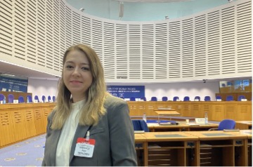 Ezgi Siir Kibris standing in a conference room.